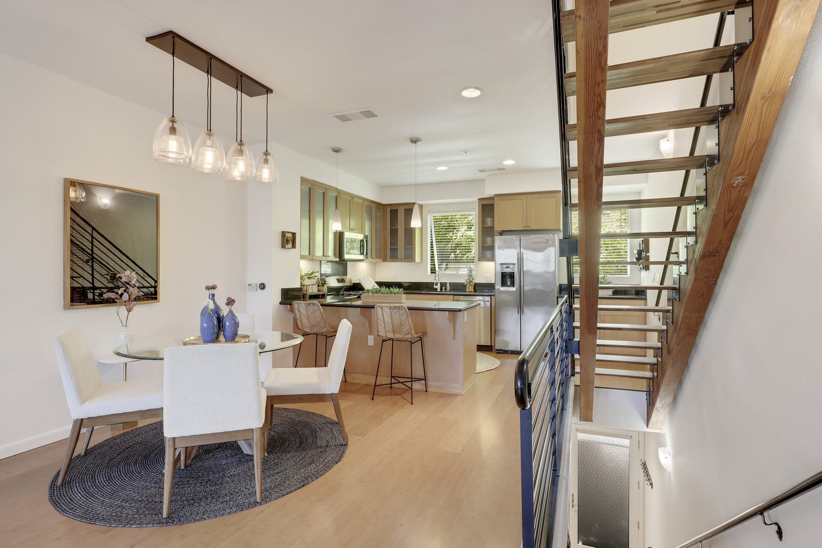 Open-concept living and dining area with a round white table, grey chairs,